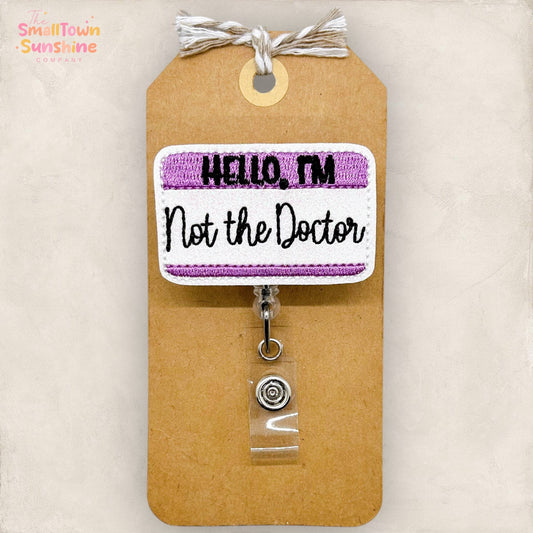 Hello, I'm Not the Doctor Badge Reel (purple): Black / Swivel